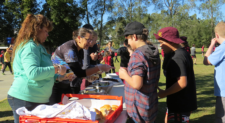 TUCKER: Students and visitors enjoy kangaroo burgers at Tea Gardens Public School.