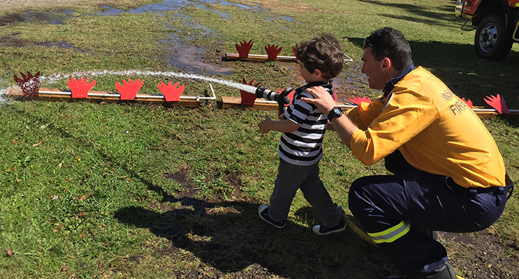 A mini fire fighter aims at the hose target to put out the flames.