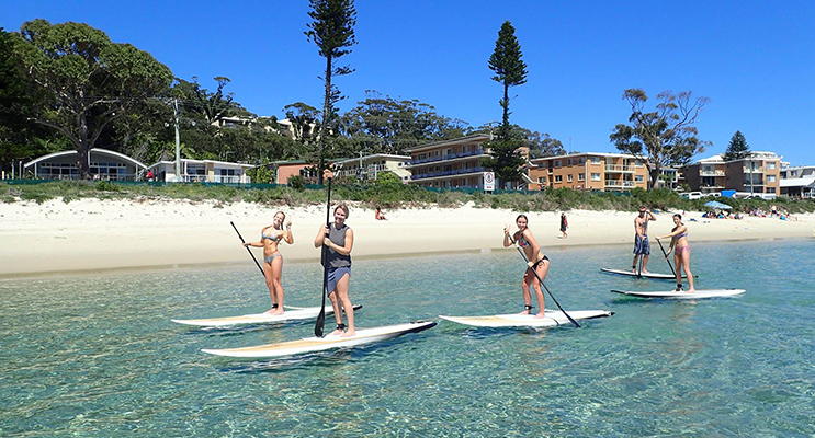 Nicole Maslowski, Mackenzie Glover, Madison Dodds and Ella Douglas enjoying SUP at Shoal Bay Beach. Photo: SUP Shoal Bay 