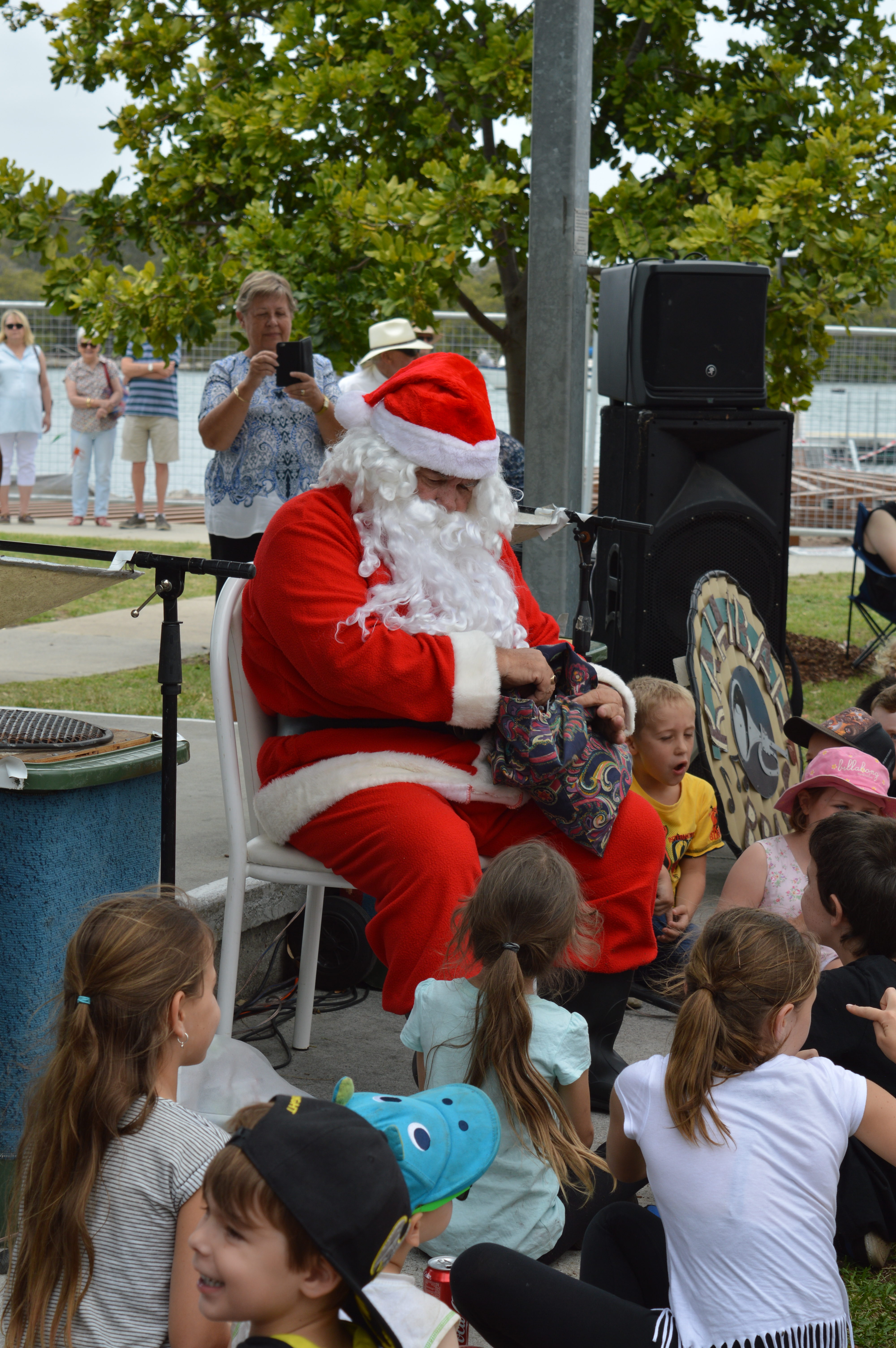 Santa hands out sweets to children after arriving on a Marine Rescue NSW boat.