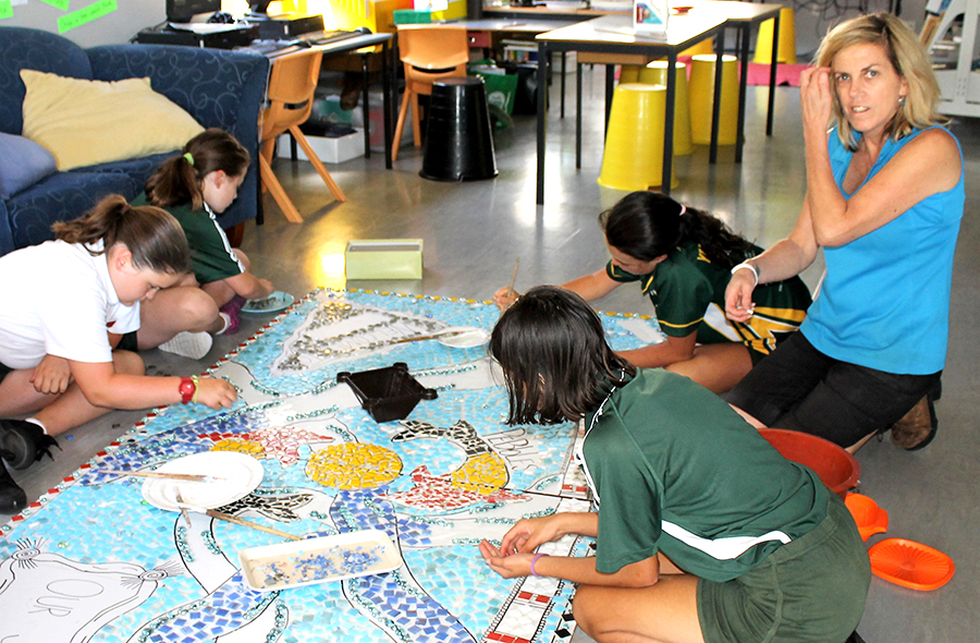 ARTWORK: Teacher Mrs Henry and students working on the mosaic.