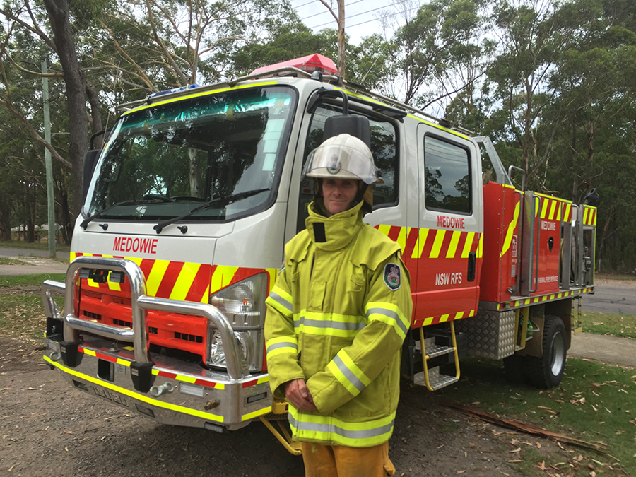 Darryl Luck in his Medowie RFS gear with one of the Brigade trucks.