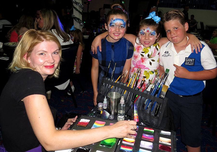 FAMILY FUN: Face painter Tennille Koelma from Rock Sloth with Margaret Stewart, Jacqueline Stewart and Riley Devine at Karuah RSL Club.