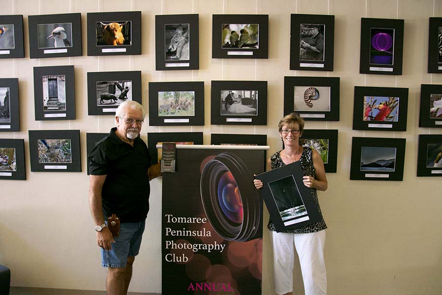 President Rudy Fuentez with Events Coordinator Vikki Ferrier changing the images on display at Tomaree Library.  Photo by Mandy Ellis