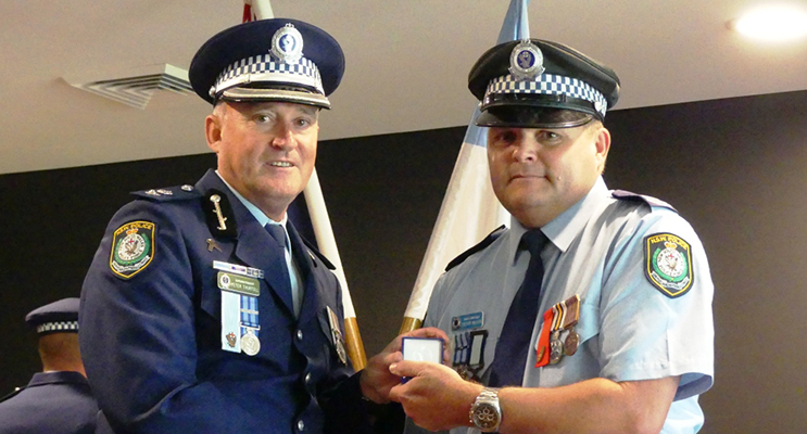 : Manning Great Lakes Commander Peter Thurtell presents the NSW Police Medal to Senior Constable Trevor Mcleod. Photo Supplied 