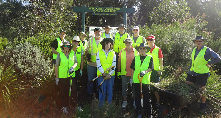 Members of the Medowie tidy towns crew with the built up, established mounds