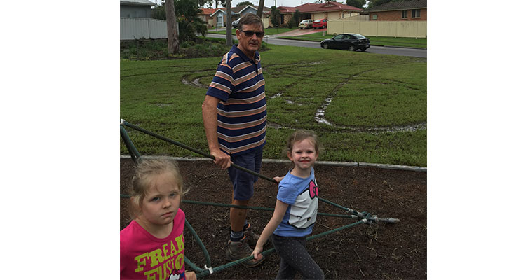 Port Stephens Councillor, Geoff Dingle with his granddaughters Jess and Katie, survey the damage done to the children's playground on Coachwood Drive. 