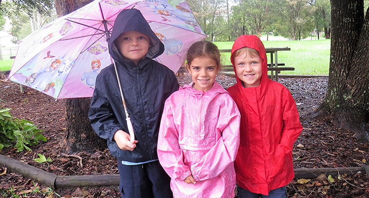 More Rain to Come: Zac Moran, Abbiegail Ray and Andrew Kent prepared with their raincoats and umbrella.