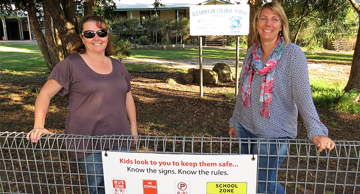 Know The Rules: BCS Deputy Principal Deb Gilbert and parent Melissa Smith, with a sign displaying the school zone traffic rules. 