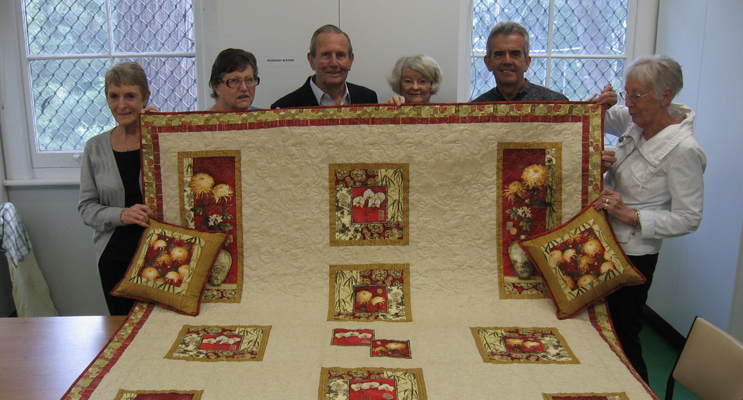Keith Norris (centre) with the quilt dedicated to the memory of his late wife Joyce.