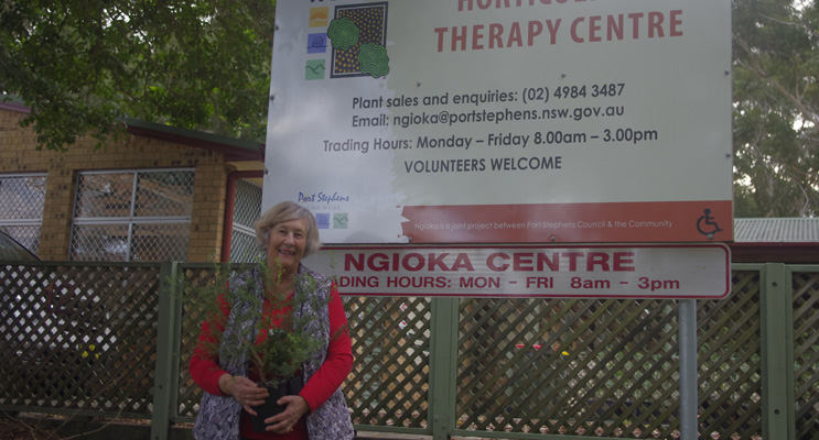 Margaret Wilkinson of Corlette Landcare at Ngioka Centre with a Coastal Rosemary Bush purchased from the Ngioka Centre.