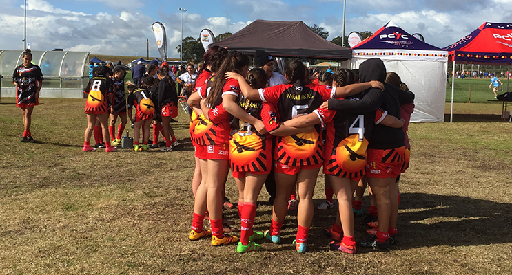 Awabakal girls team huddle at the Rugby League.