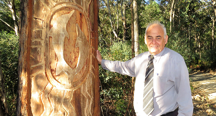 Len Roberts at the tree carving of dolphins at the base of Alum Mountain.