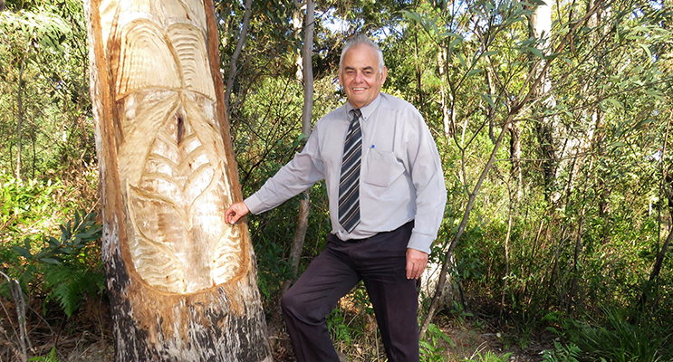 Land Council CEO Len Roberts at the tree carving of a whale at the heads. 