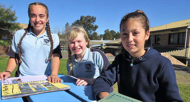 BCS Year 9 student Tahlia Mancini practices for the K-12 Spelling Bee with Year 6 students Maggie Cunich and Maddi Tassell. 