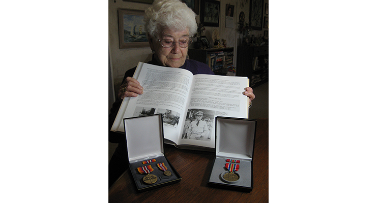 Never forgotten – Margaret reflects on a photo of Frede in Bill Lunney's 'Forgotten Fleet 2.' His service medals are beside the book. 