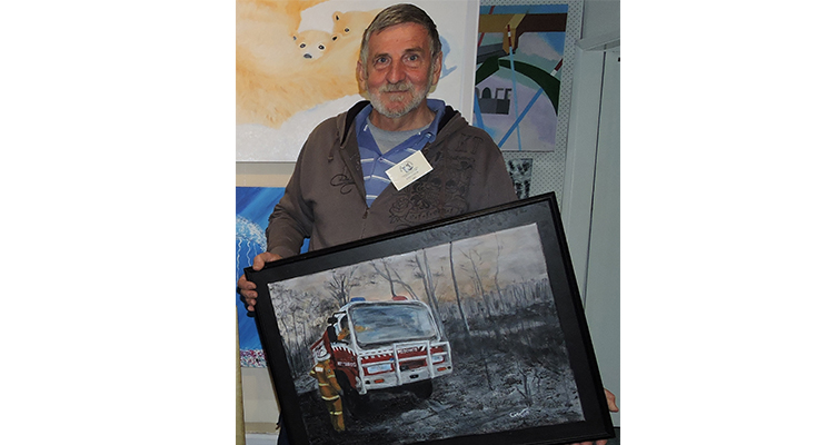 John Crew with his artwork that can be viewed at the exhibition.