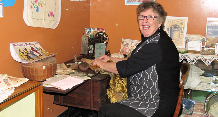 Diane Burns with a sewing machine on display at the Courthouse Museum. 
