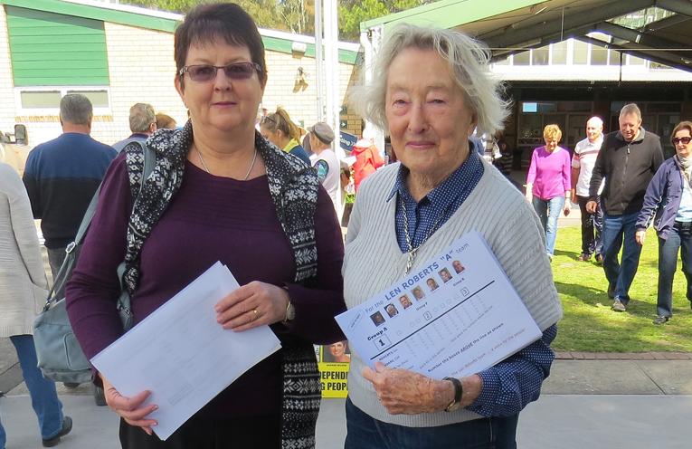 Stephanie Weeks receives a how to vote card from ‘A Team’ volunteer Marcia Dane in Tea Gardens.