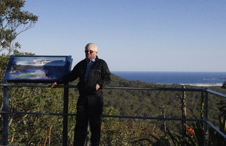 Darrell Dawson at Gan Gan Lookout with part of the environment that local groups have saved from development in the background. Photo by Marian Sampson.