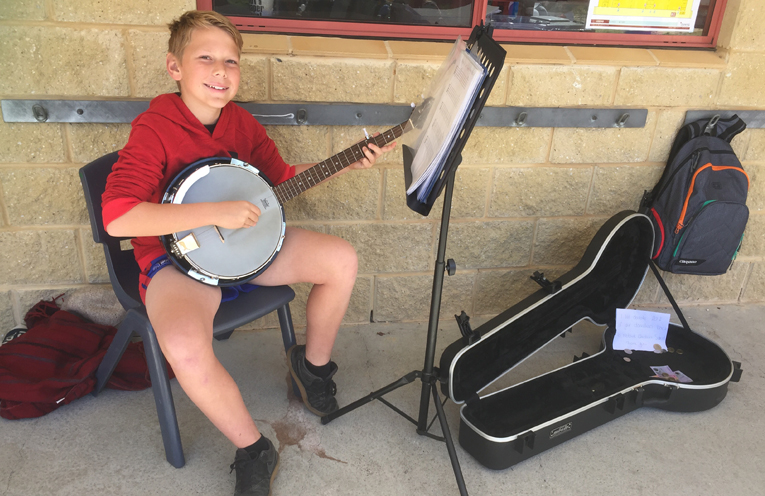 Jack Ryner, 12, busking with his banjo.