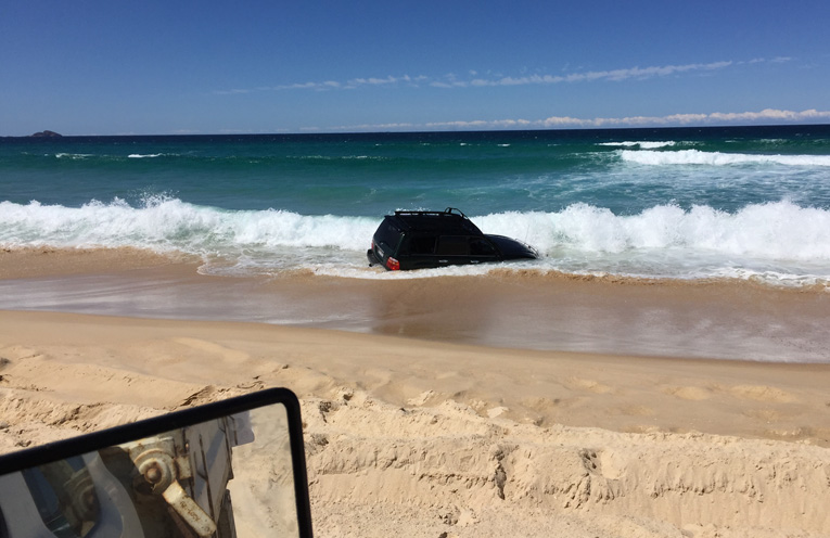 HAWKS NEST: Landcruiser ends up in the surf. Photo: Levi Peters