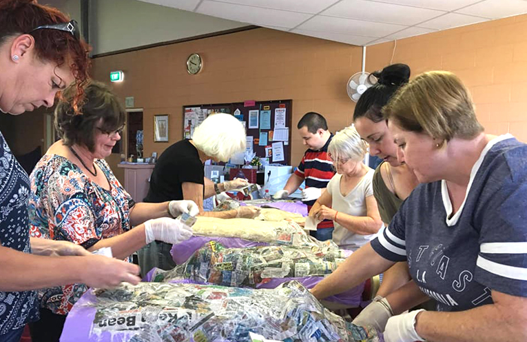 Julie Bailey and some of the participants, getting paper mache pieces ready for their upcoming art program.