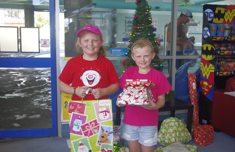 Olivia and Lara Brett at the Camp Quality Christmas party with their Christmas gifts. Photo by Marian Sampson.