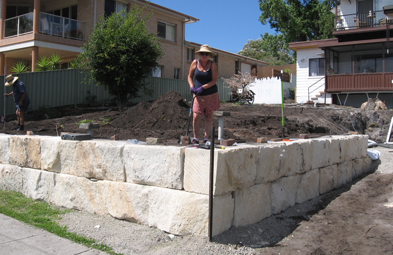 Tracy, her wall and sandstone blocks waiting to be positioned.