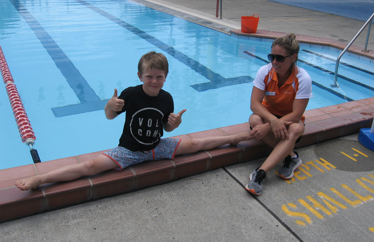 Josh showing his flexibility with his proud parent beside the pool. 