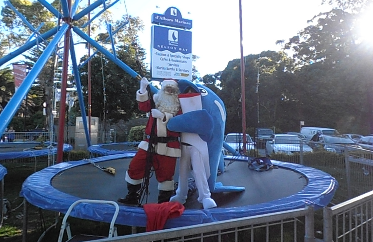 Santa and Splash Nelson Bay’s Town Mascot enjoying the Aero Trampolining at Nelson Bay. Photo by Marian Sampson.