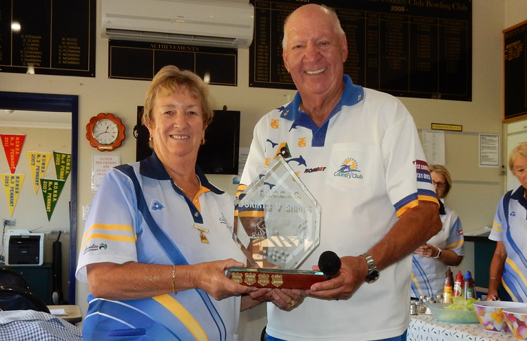 Women's Bowling Club President, Robyn Webster presenting the Men's Bowling Club President, Max Stephens, with the Dolphin Day "Shirts v Skirts" trophy.