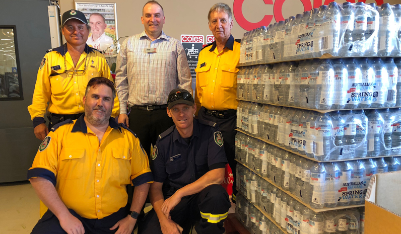 Medowie RFB members with Medowie Coles Manager David Fulton and some water slabs to be donated to the Fire Station.