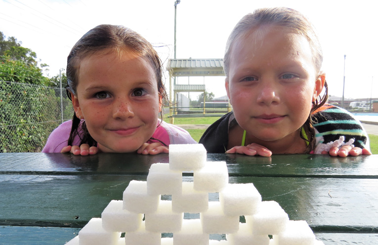 Lucy Collison and Bella Watling show the amount of sugar contained in a large frozen drink. 
