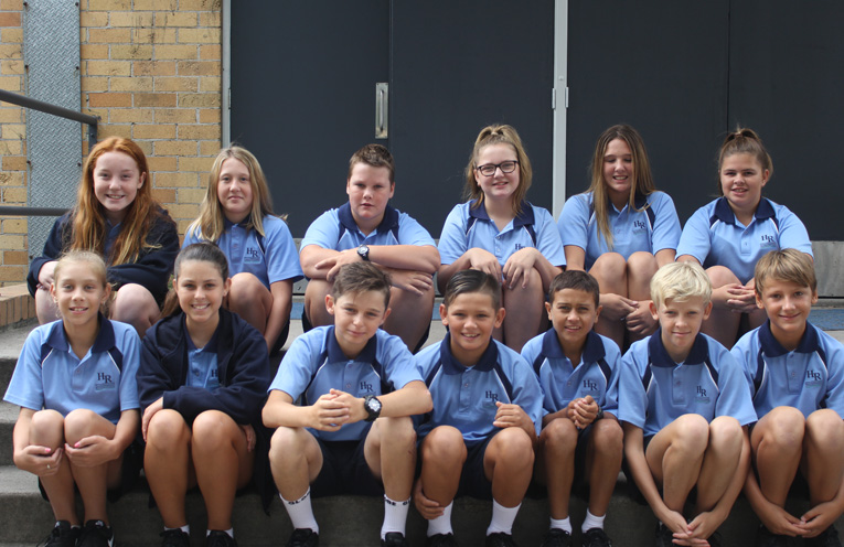 Fresh faced Year 7 students on the steps of the hall at Hunter River High School.