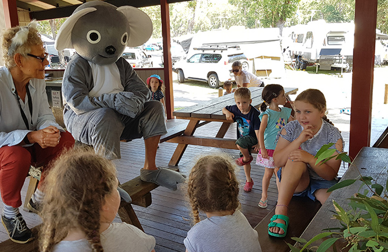 Adrienne Ingram and koala Peter Rogers talking to children at the Reflections Holiday Camp, Hawks Nest.