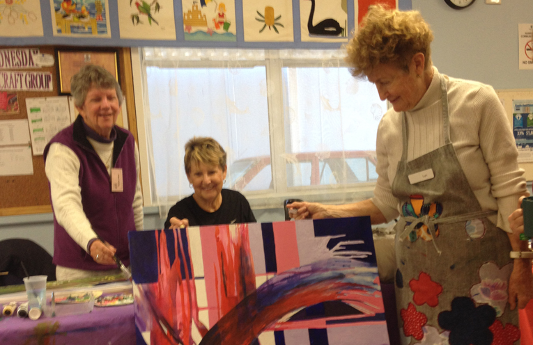  Members of the U3A Art Group: Heather Miller, Carolyn Morrison and Lyn Blake prepare one of the paintings to go on display.